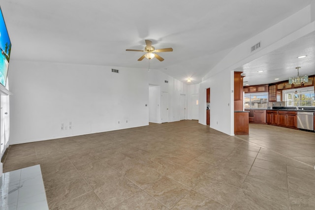 unfurnished living room with lofted ceiling, ceiling fan with notable chandelier, and visible vents