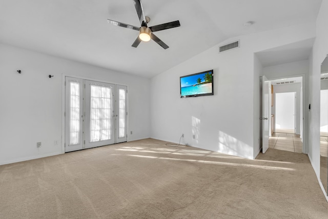 empty room with lofted ceiling, a ceiling fan, visible vents, and light colored carpet