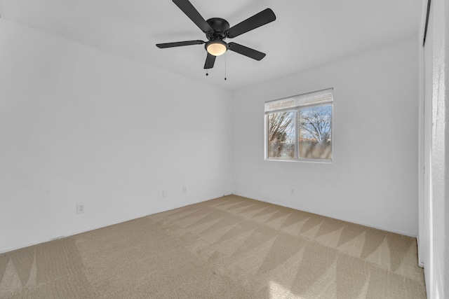 spare room with a ceiling fan and carpet