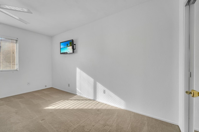 unfurnished room featuring light colored carpet and baseboards