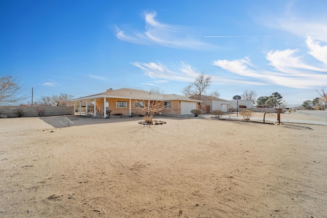 back of property featuring driveway and fence