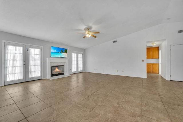 unfurnished living room featuring lofted ceiling, a wealth of natural light, and french doors