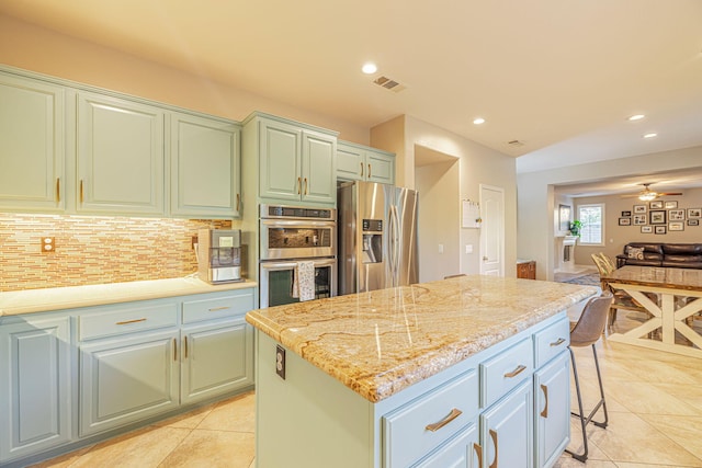 4104 Rainer Pl, Quartz Hill, CA 93536 - kitchen featuring stainless steel appliances, a center island, backsplash, open floor plan, and light tile patterned floors