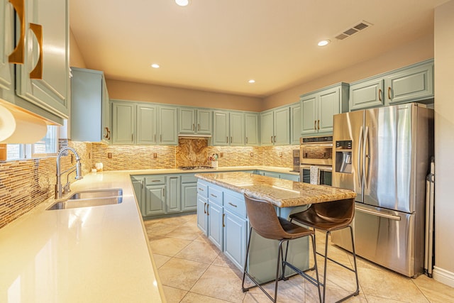 4104 Rainer Pl, Quartz Hill, CA 93536 - kitchen featuring appliances with stainless steel finishes, a sink, a center island, tasteful backsplash, and recessed lighting