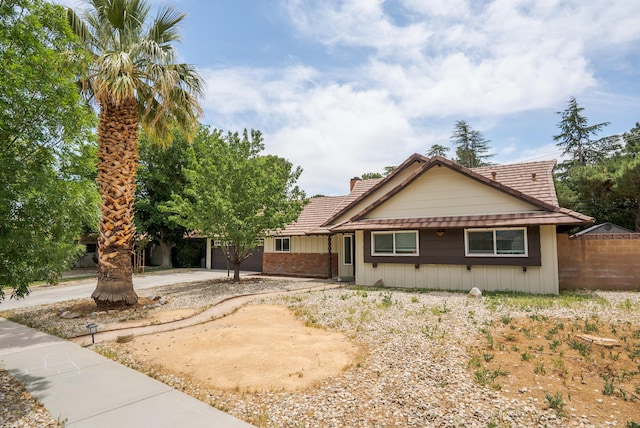 43818 Halcom Ave, Lancaster, CA 93536 - view of front facade featuring a tile roof, a garage, board and batten siding, and concrete driveway
