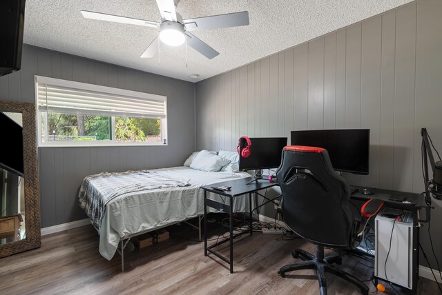43818 Halcom Ave, Lancaster, CA 93536 - bedroom with a textured ceiling, wood finished floors, an office area, a ceiling fan, and baseboards