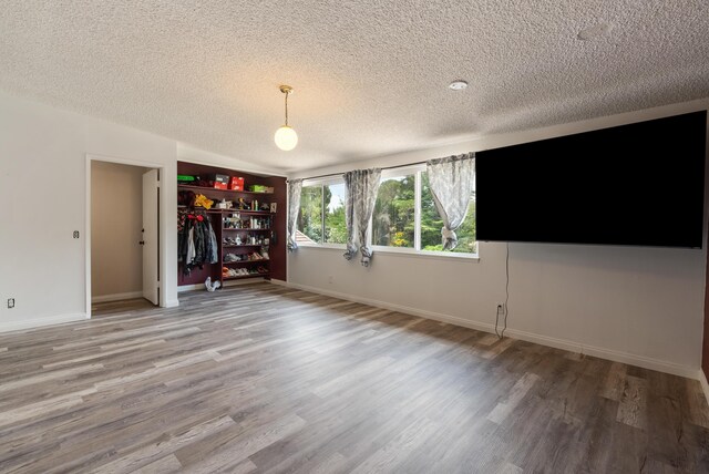 43818 Halcom Ave, Lancaster, CA 93536 - unfurnished living room featuring a textured ceiling, light wood-type flooring, and baseboards