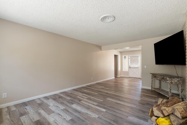 43818 Halcom Ave, Lancaster, CA 93536 - unfurnished living room with a textured ceiling, wood finished floors, and baseboards