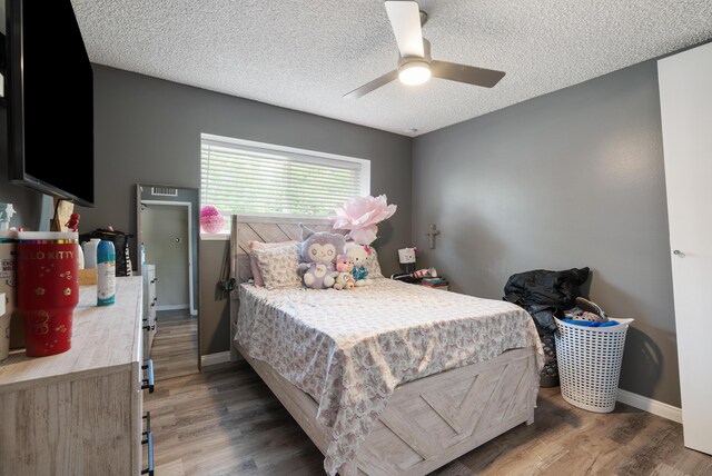 43818 Halcom Ave, Lancaster, CA 93536 - bedroom with wood finished floors, a textured ceiling, baseboards, and a ceiling fan