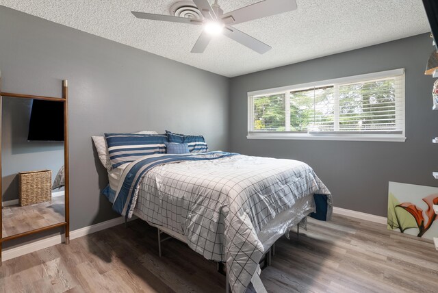 43818 Halcom Ave, Lancaster, CA 93536 - bedroom featuring a textured ceiling, wood finished floors, baseboards, and a ceiling fan