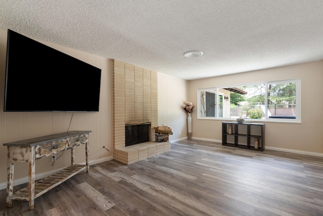 43818 Halcom Ave, Lancaster, CA 93536 - living area featuring a textured ceiling, wood finished floors, a fireplace, and baseboards