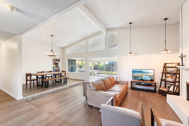 living area featuring high vaulted ceiling, a textured ceiling, baseboards, wood finished floors, and beam ceiling