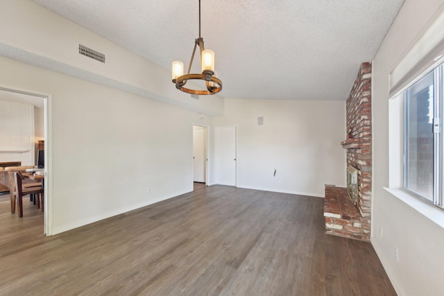 living area with a notable chandelier, visible vents, wood finished floors, and a healthy amount of sunlight