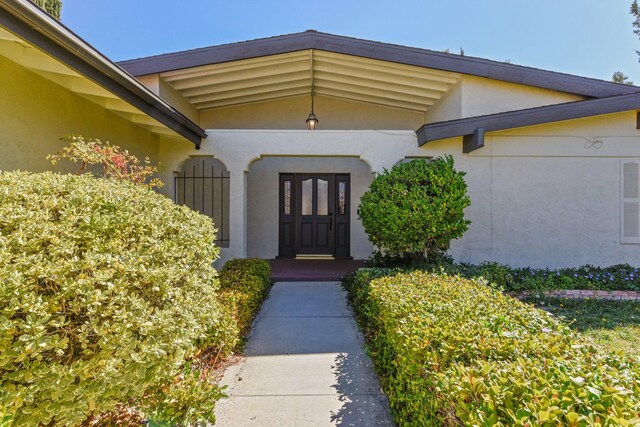 property entrance with stucco siding
