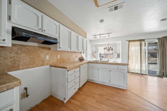 kitchen with visible vents, white cabinets, light wood-type flooring, dishwasher, and under cabinet range hood