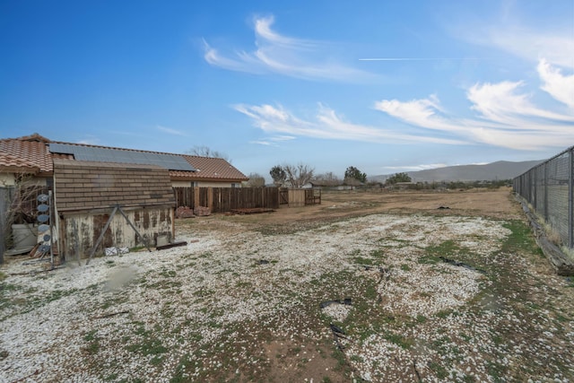 view of yard featuring an outbuilding, a storage shed, and fence