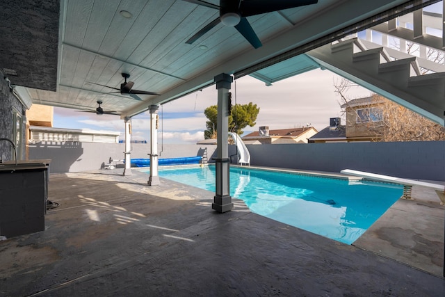 view of swimming pool featuring a diving board and a patio