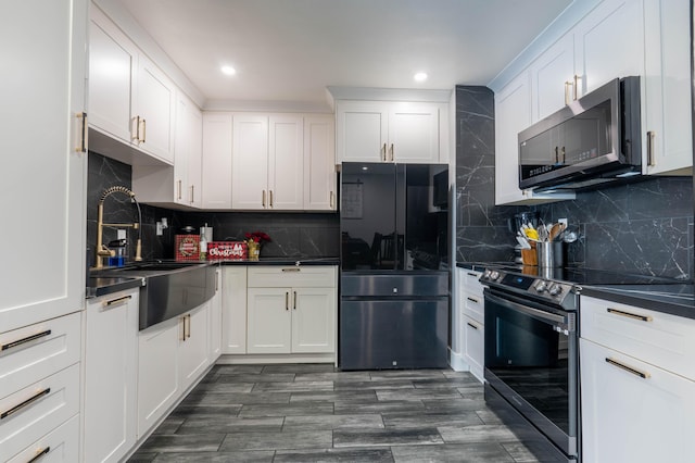 kitchen with black appliances, decorative backsplash, white cabinetry, and sink