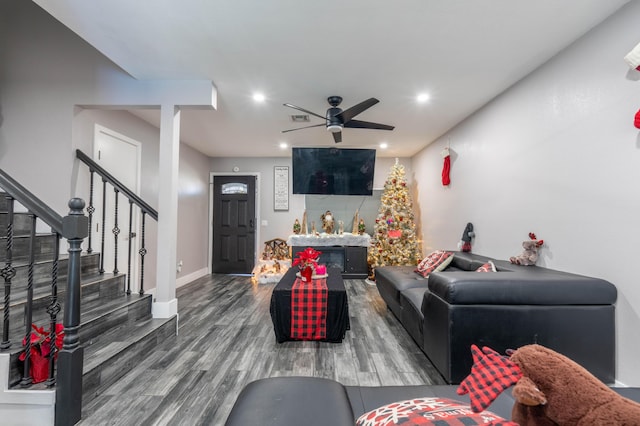 living room featuring ceiling fan and dark hardwood / wood-style flooring