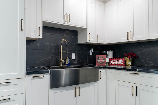 kitchen with tasteful backsplash, sink, and white cabinets