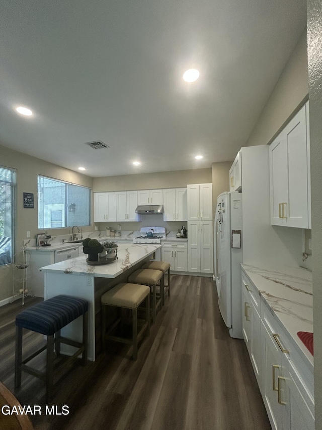 38836 Calistoga St, Palmdale, CA 93551 - kitchen featuring white appliances, under cabinet range hood, dark wood finished floors, white cabinetry, and recessed lighting