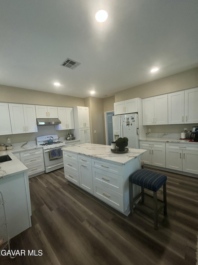 38836 Calistoga St, Palmdale, CA 93551 - kitchen with white appliances, under cabinet range hood, white cabinetry, dark wood-type flooring, and recessed lighting