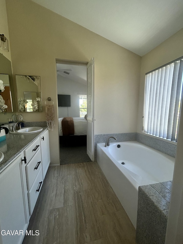 38836 Calistoga St, Palmdale, CA 93551 - ensuite bathroom featuring vaulted ceiling, double vanity, a bath, and wood finished floors