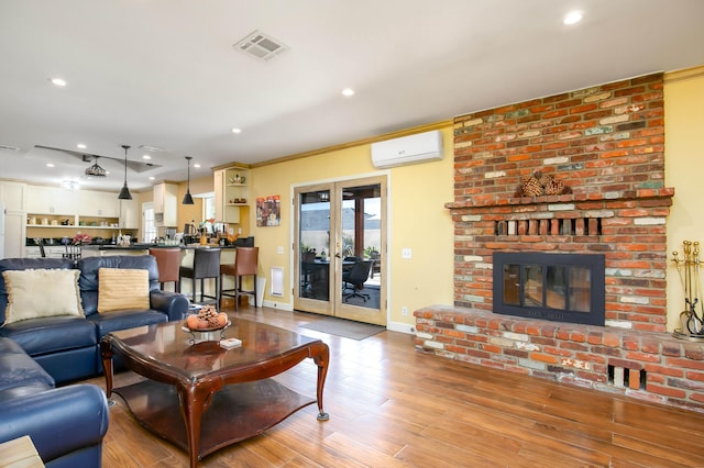 3215 Larwood Dr, Lancaster, CA 93536 - living room featuring an AC wall unit, recessed lighting, a brick fireplace, and visible vents