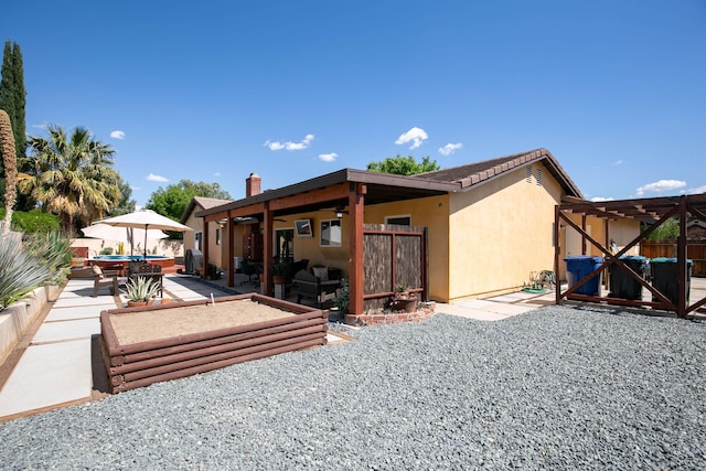 3215 Larwood Dr, Lancaster, CA 93536 - back of property with a patio, fence, stucco siding, and a chimney