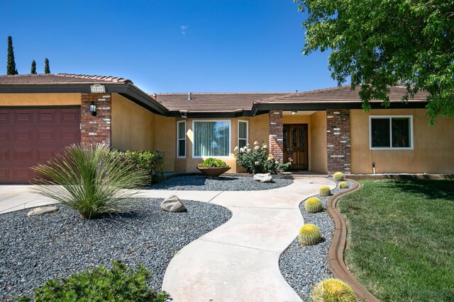 3215 Larwood Dr, Lancaster, CA 93536 - single story home with an attached garage, a tile roof, stucco siding, and brick siding