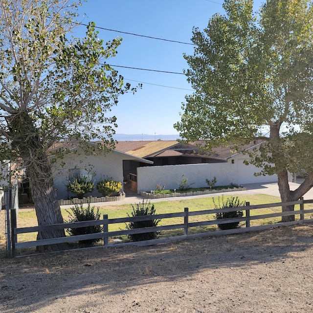 view of front of property with a fenced front yard, a front yard, and stucco siding