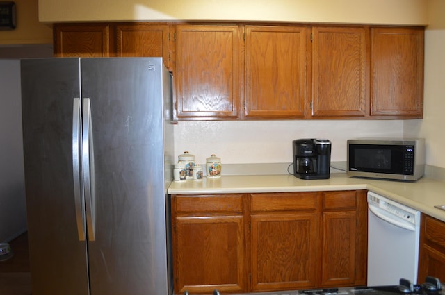 kitchen featuring light countertops, appliances with stainless steel finishes, and brown cabinets