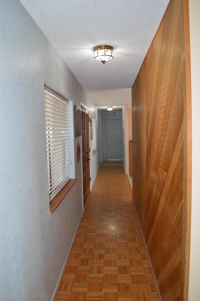 hall featuring a textured ceiling