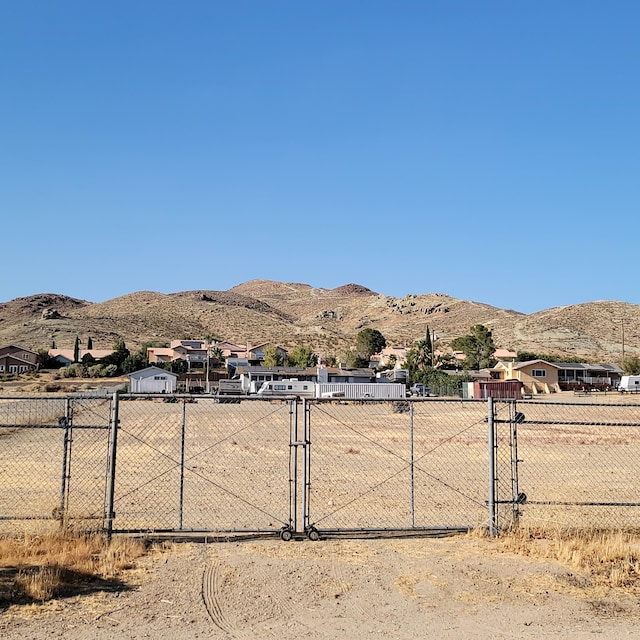 view of yard featuring a gate, fence, and a mountain view