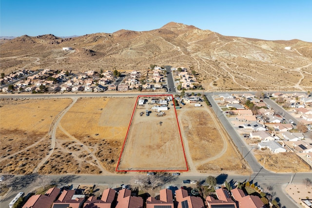 drone / aerial view featuring a residential view, view of desert, and a mountain view