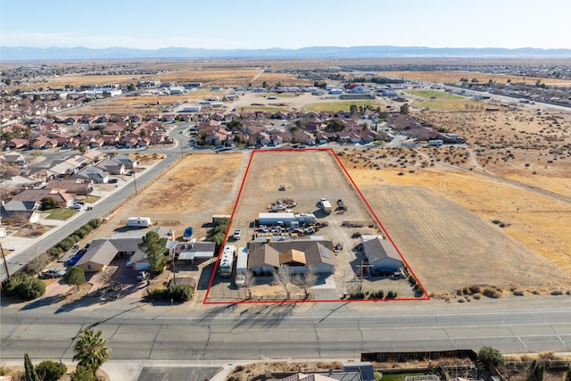 drone / aerial view with view of desert, a residential view, and a mountain view