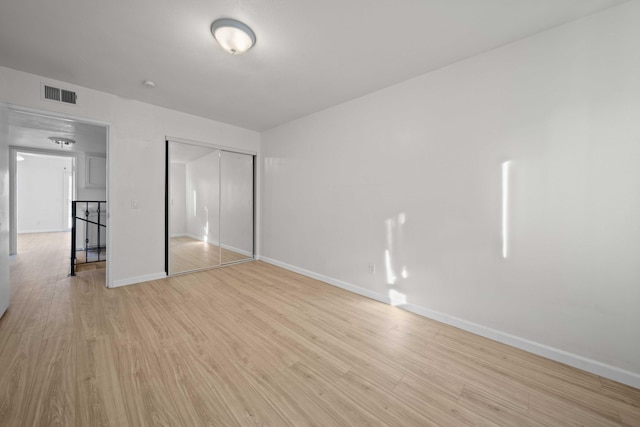 unfurnished bedroom featuring a closet and light hardwood / wood-style flooring