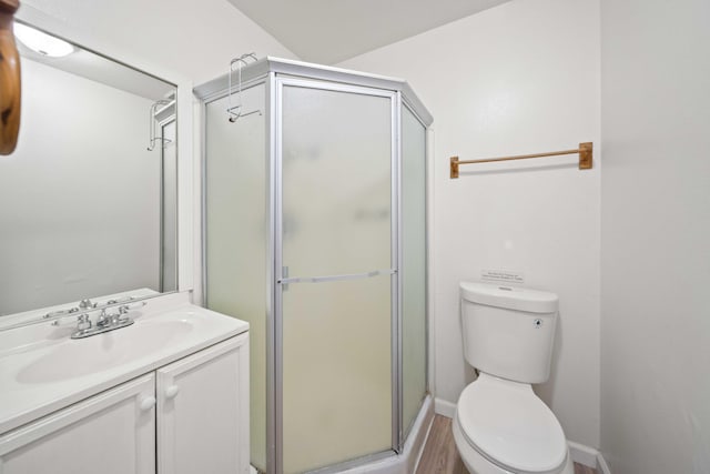 bathroom featuring vanity, an enclosed shower, and toilet