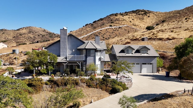 view of front of home with a mountain view and a balcony