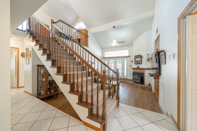 stairway featuring ceiling fan, tile patterned flooring, and a high ceiling