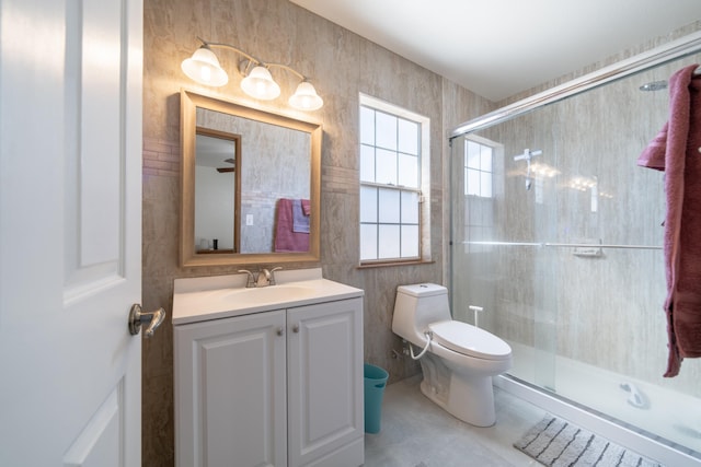 bathroom featuring vanity, a shower with door, ceiling fan, tile patterned flooring, and toilet