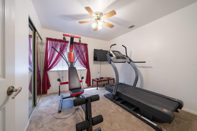 workout room featuring light carpet and ceiling fan