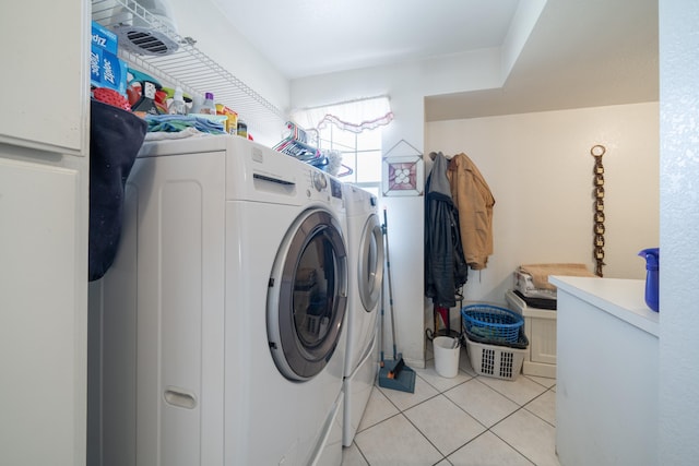 clothes washing area with washing machine and dryer and light tile patterned floors