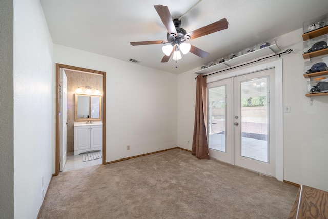 spare room with french doors, light colored carpet, and ceiling fan