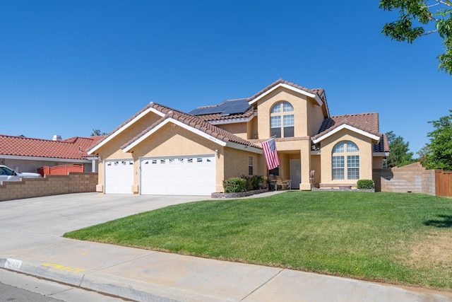 mediterranean / spanish-style home featuring solar panels, a garage, and a front yard