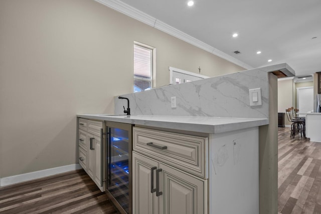 kitchen with crown molding, wine cooler, dark hardwood / wood-style floors, tasteful backsplash, and light stone counters