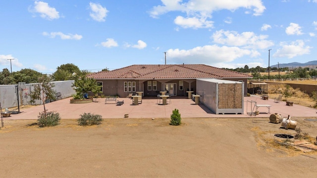 rear view of house with a mountain view and a patio