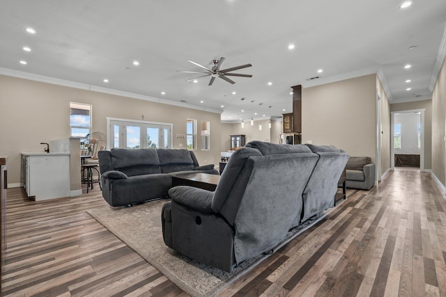 living room featuring hardwood / wood-style floors, ceiling fan, ornamental molding, and french doors