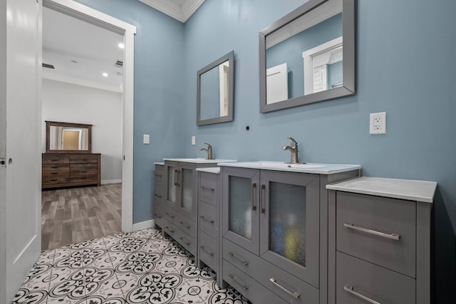 bathroom with crown molding, hardwood / wood-style floors, and vanity