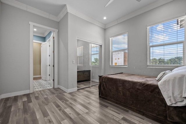 bedroom with ceiling fan, a closet, wood-type flooring, and ornamental molding